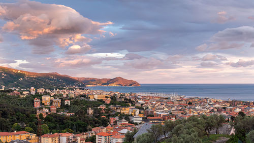 High angle view of townscape by sea against sky