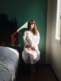 Portrait of young woman sitting at home