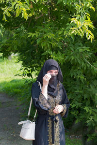 Muslim woman wipes sweat with a handkerchief from her face summer heat. person