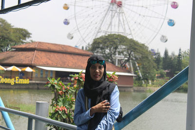 Portrait of young woman standing in city