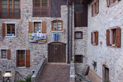 Ancient restored house with stone walls and wooden windows with hanging  laundry