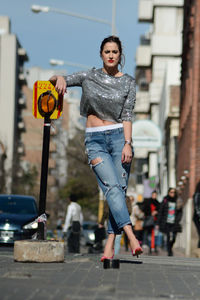 Full length of fashionable woman standing on street in city