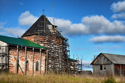 Old house on field against sky