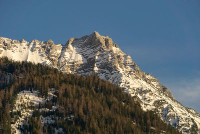 Low angle view of snowcapped mountain against sky