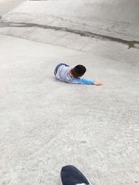 High angle view of boy lying on footpath