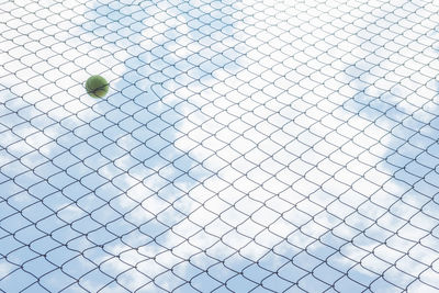 Low angle view of ball on fence against sky