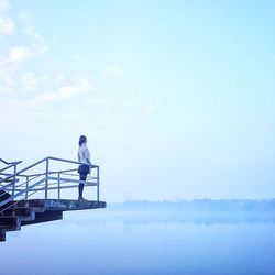 Rear view of woman standing at observation point over lake