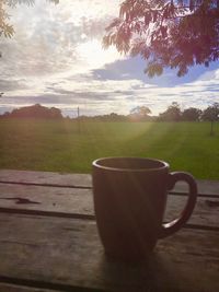 Coffee cup on table against sky