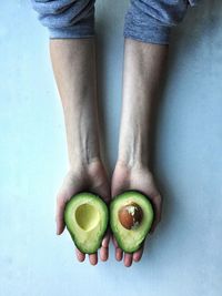 Cropped hand holding avocados