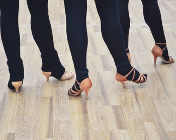 Low section of people standing on wooden floor