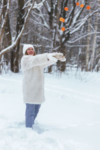 Rear view of woman standing on snow covered field