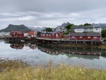 Houses by sea against sky and mountains 