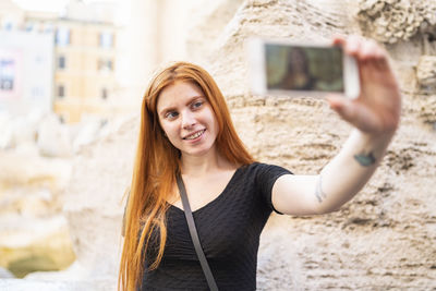 Modern female traveler taking selfie with smartphone