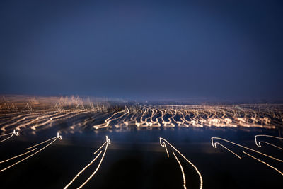 Light trails on road against sky at night