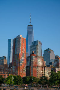 Buildings in city against clear blue sky