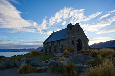 Historic building church against sky near a lake in the early morning 