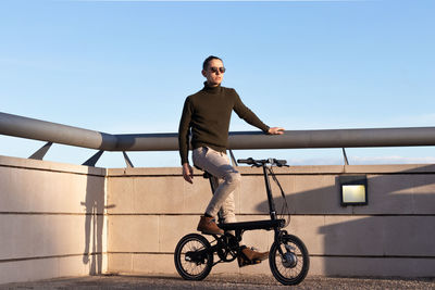 Young man riding an electric bike as a sustainable urban transportation to avoid pollution