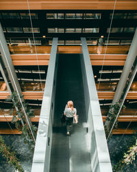 High angle view of woman on escalator in building