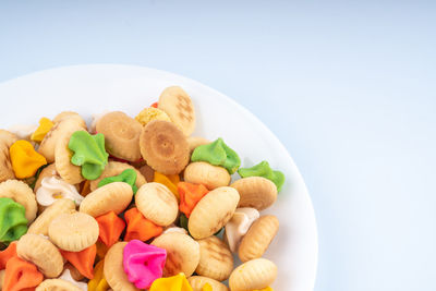 Close-up of multi colored candies in plate against white background