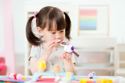 Young girl decorating hand made craft for homeschooling