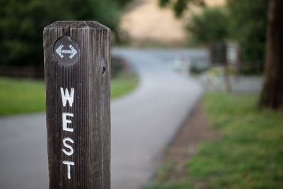 Close-up of information sign on wooden post