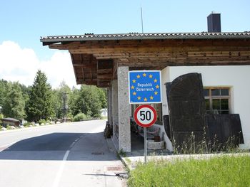 Information sign by road against sky