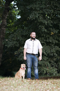 Portrait of woman with dog against plants