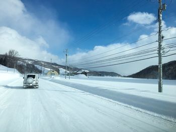 Cars on road against sky during winter