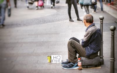 Full length of man sitting on street