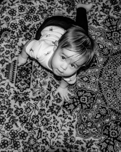 High angle portrait of cute girl lying on carpet