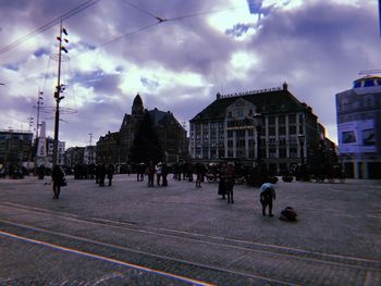 People walking on street amidst buildings in city