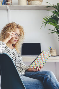 Portrait of young woman using laptop at home