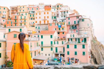 Rear view of woman against buildings in city