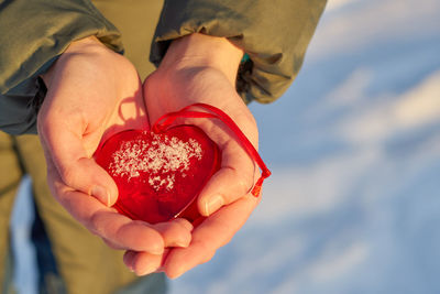 Midsection of woman holding heart
