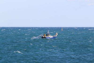 Boat sailing in sea against clear sky