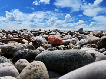 Surface level of pebbles at beach against sky