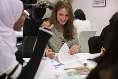 Young student reading notes sitting in classroom