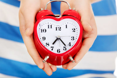 Cropped hands of child holding alarm clock
