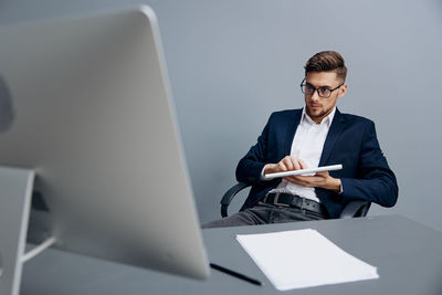 Portrait of businessman using laptop while sitting in office