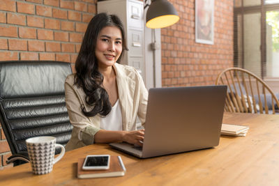 Woman using laptop on table at cafe