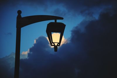 Low angle view of illuminated street light against sky