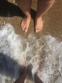 Low section of person standing on beach