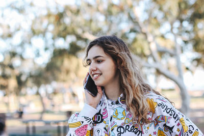 Pretty teenager girl talking by phone 