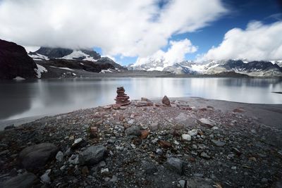 Scenic view of lake and mountains against cloudy sky