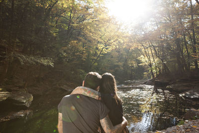 Young couple sitting near a stream