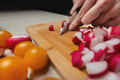 Pink radish is cut with a knife in the kitchen. concept of healthy food salad, vegetables. closeup