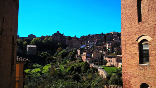 Buildings against clear blue sky in city