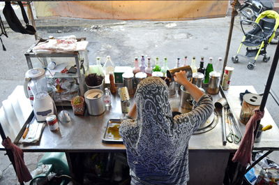 High angle view of woman preparing drink at market stall