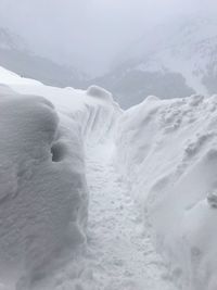 Snow covered landscape against sky