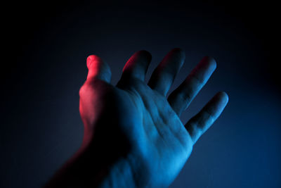 Close-up of human hand against black background